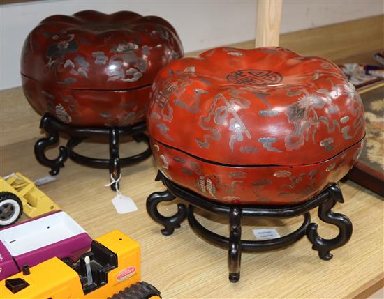 A pair of Chinese red lacquer melon form lidded boxes, on hardwood stands, height 30cm